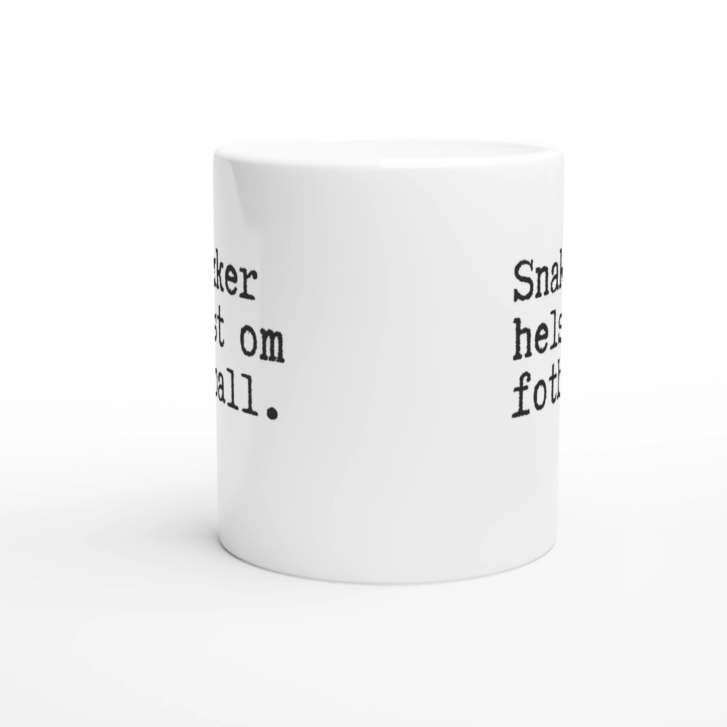 Hvitt krus med sort tekst som sier "Snakker helst om fotball." i minimalistisk skrivemaskinstil.