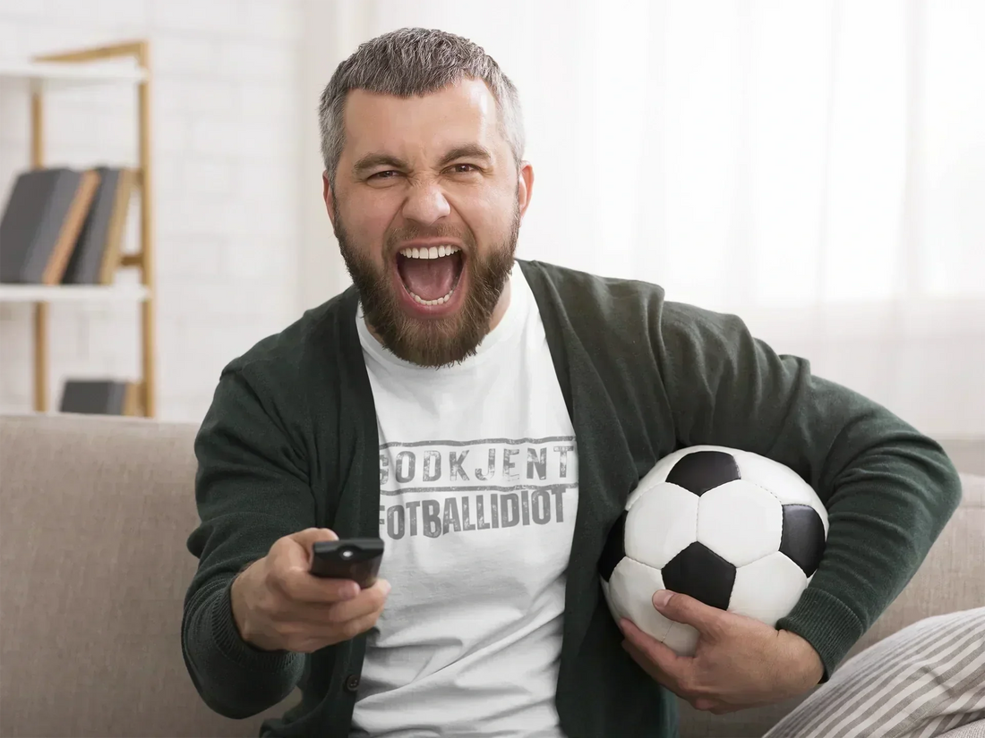 Fotballsupporter som ser på en fotballkamp på TV.