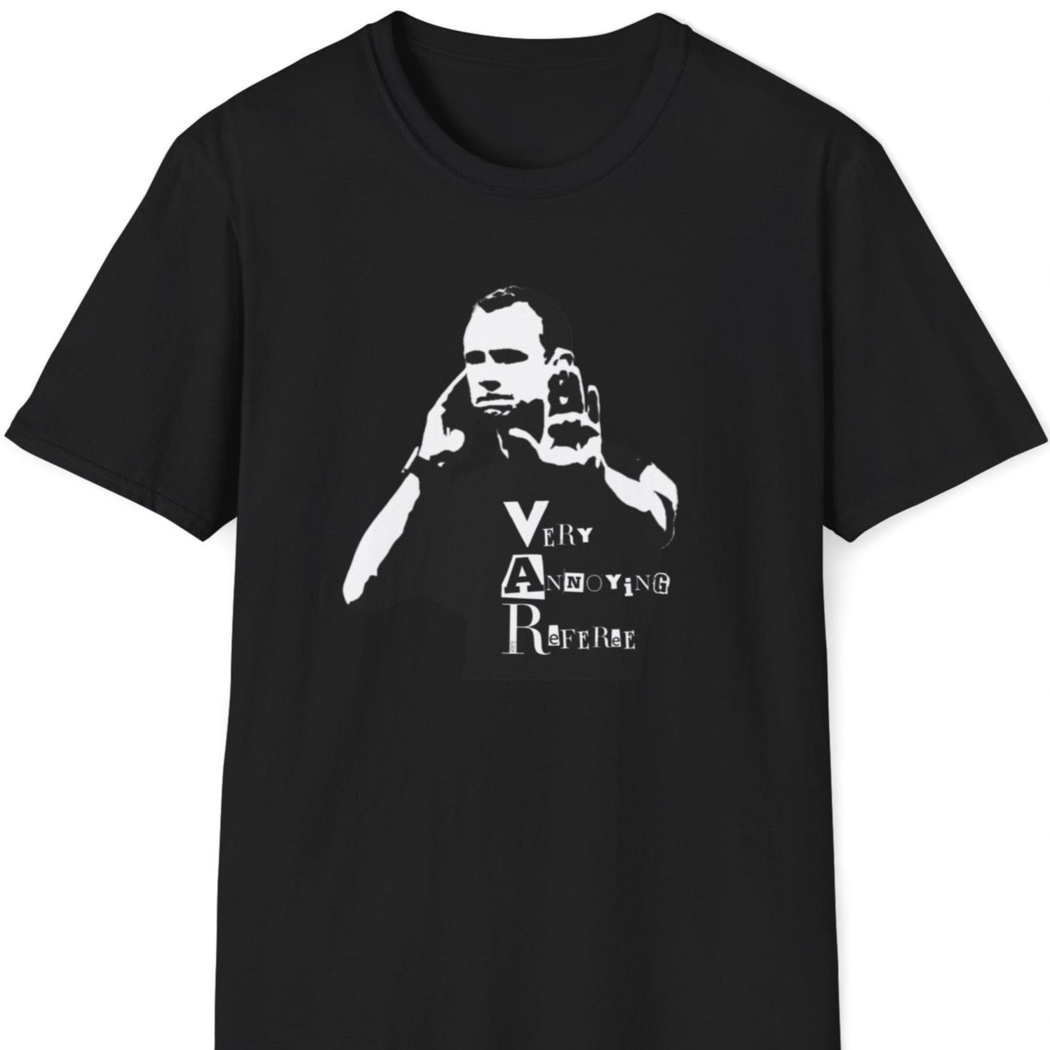 Skjeggete mann med blå caps og tatoveringer står mot en rusten metallvegg, iført en svart T-skjorte med et stilisert motiv av en dommer som bruker VAR, og teksten "Very Annoying Referee" i en klippet bokstavstil.