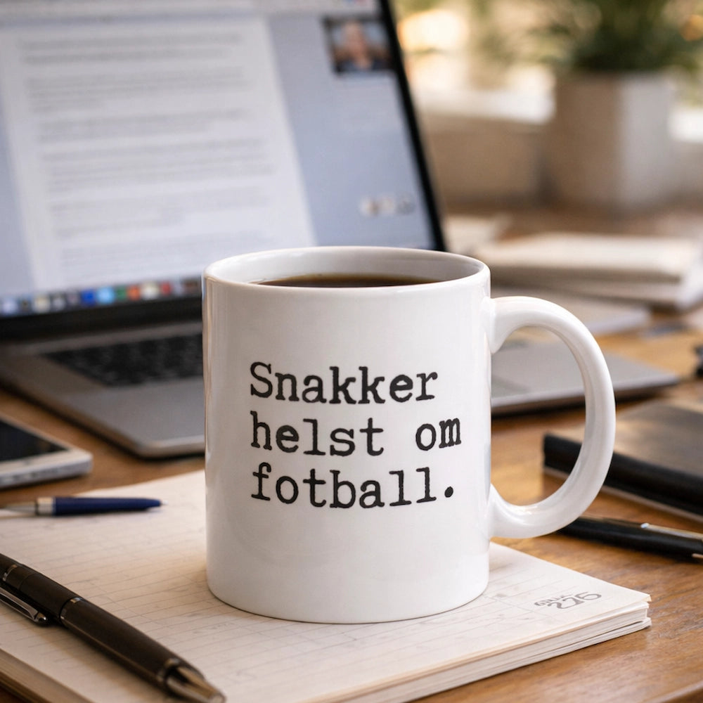 En kaffekopp med teksten "Snakker helst om fotball" ved siden av en laptop som viser et videomøte.